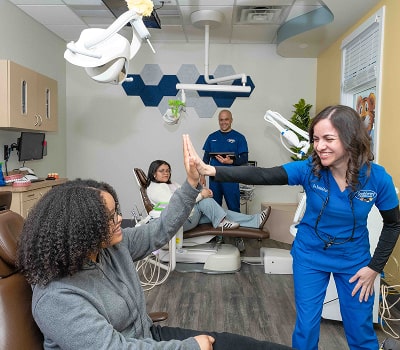 South Jersey Pediatric dentist is smiling and high-fiving a joyful kid