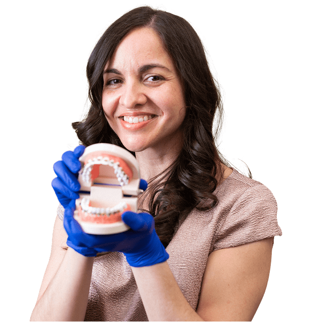 South Jersey Pediatric dentist is smiling and holding a model of a jaw