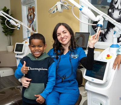 Top South Jersey dentist is smiling with a young happy patient