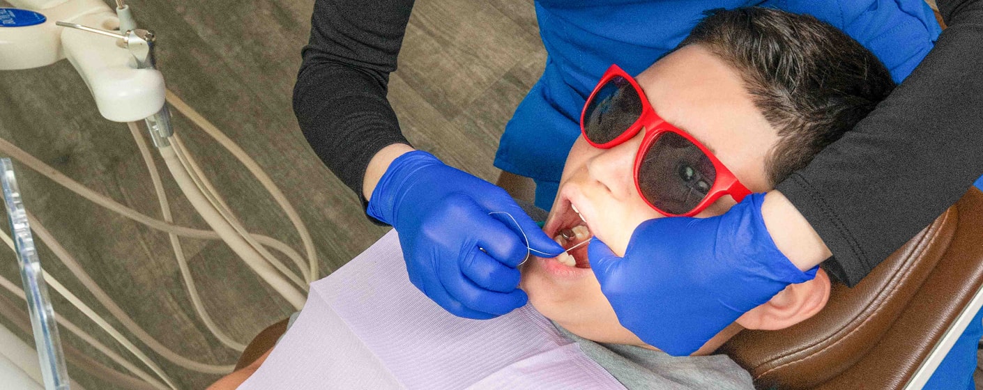 A boy in a dental chair enjoying dental procedure