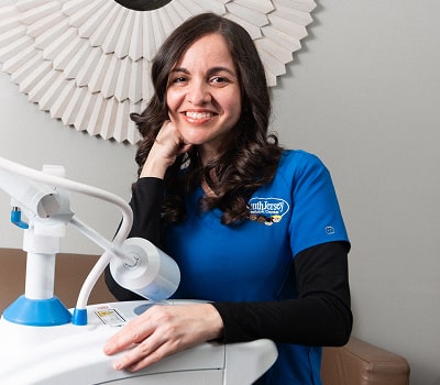 Dr. Brendaliz is happily smiling with a hand near her face
