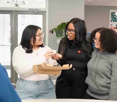 Dr. Brendaliz is happily and making heart with her hand and dental equipment