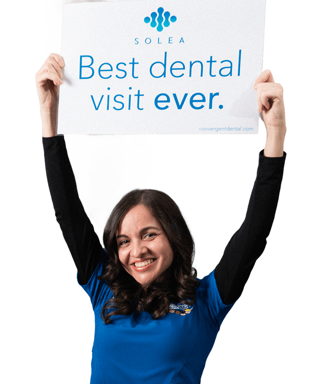 South Jersey dentist smiling and holding Best Dental Visit sign