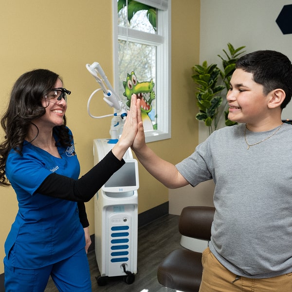 Teenager is smiling together with his dentist