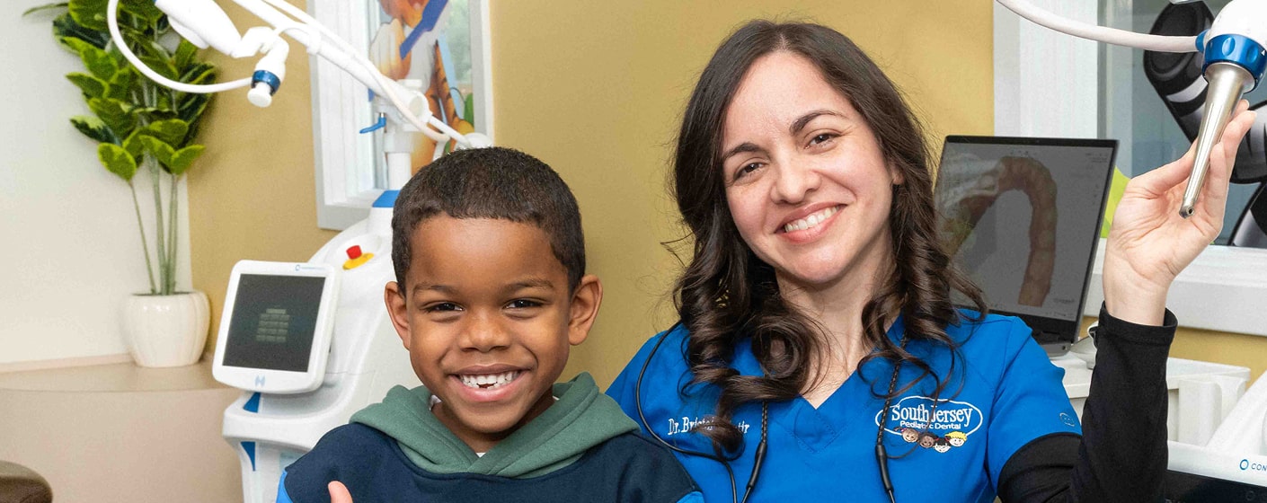 Top South Kersey dentist is smiling with her young patient